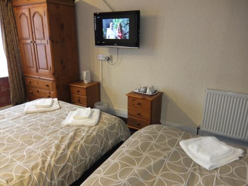 a hotel room with two beds and a flat screen tv at The Monsell Hotel in Skegness