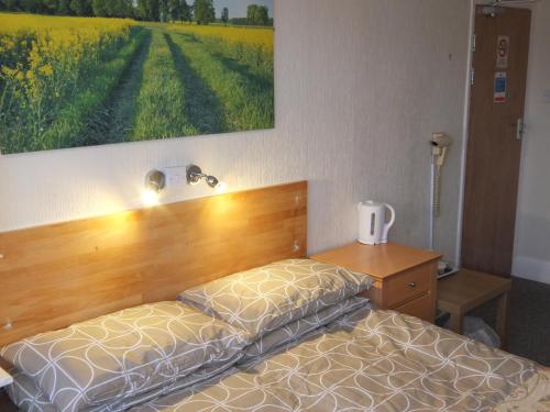 a bedroom with a bed and a painting on the wall at The Monsell Hotel in Skegness