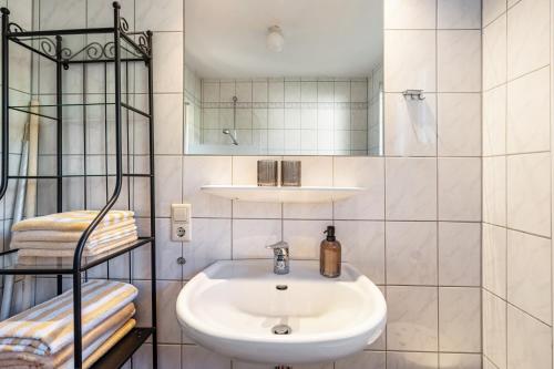 a white bathroom with a sink and a shower at Dorerhof Prechtal in Elzach