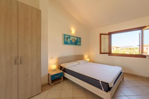 a small bedroom with a bed and a window at Casa Vacanze Cocco in Porto San Paolo