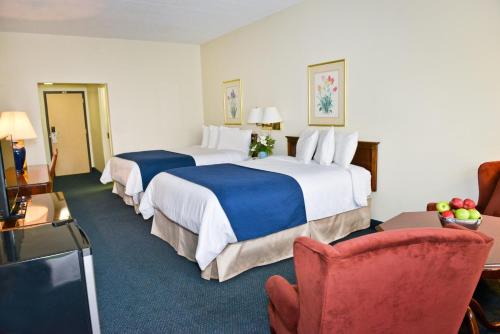 a hotel room with two beds and a chair at Penn Wells Lodge in Wellsboro