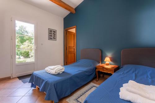 two beds in a room with blue walls at Maison d'hôtes Collobrières in Collobrières