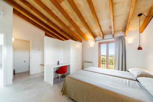 a bedroom with two beds and a desk at Cases d’Alcudiarrom in Vilafranca de Bonany