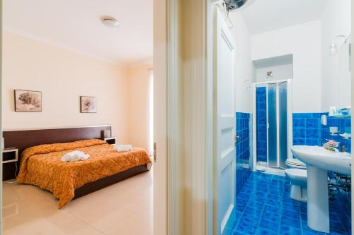 a bedroom with a bed and a bathroom with a sink at Palazzo Mongiò in Gallipoli