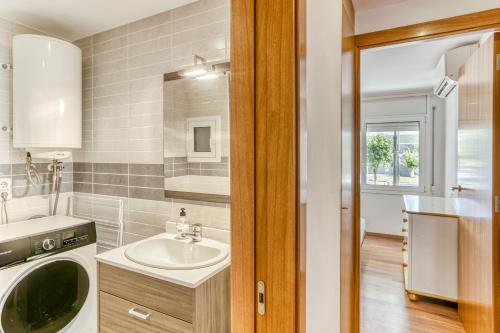 a bathroom with a sink and a washing machine at Olga in Platja d'Aro