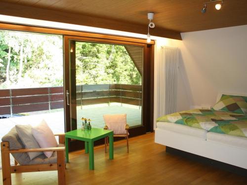 a bedroom with a bed and a green table at Haus Talblick Sasbachwalden in Sasbachwalden