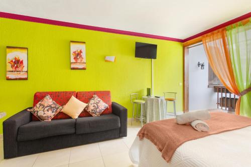 a bedroom with a couch and a green wall at Arcoiris Al Mar Playa San Marcos in San Marcos