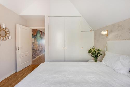 a white bedroom with a large bed and a closet at Apartamento T1 - Salina Ria in Aveiro