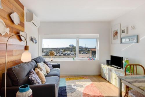 a living room with a couch and a window at Apartamento T1 - Salina Ria in Aveiro