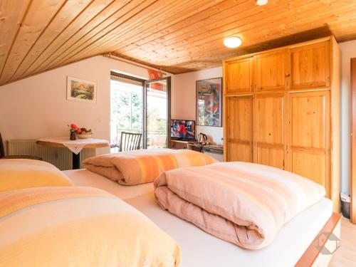 a bedroom with three beds and a wooden ceiling at Haus Umbeer in Schömberg
