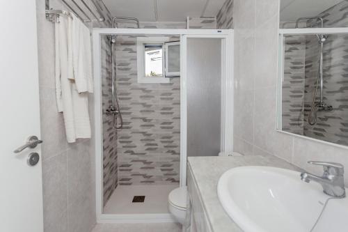 a bathroom with a shower and a sink and a toilet at Cala en Forcat in Menorca