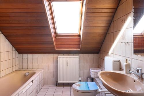 a bathroom with a sink toilet and a window at Heidi's Panoramablick in Neuerode