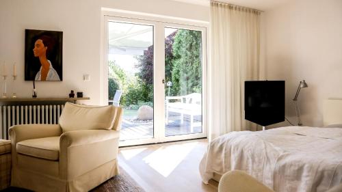 a bedroom with a bed and a chair and a sliding glass door at Ferienwohnung Jung und Lind in Bretten