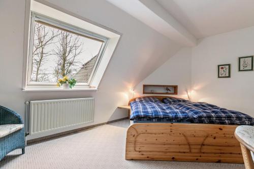 a bedroom with a wooden bed and a window at Alte Bäckerei - Nis Puk in Rodenäs