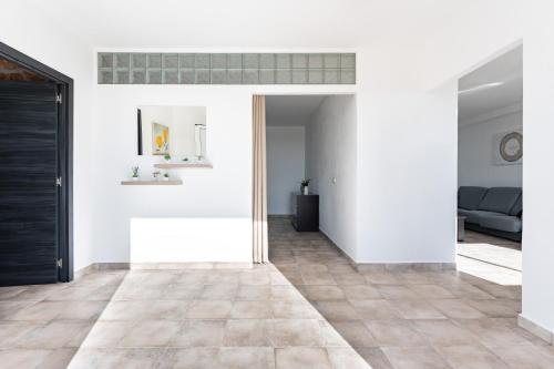 a living room with white walls and a tile floor at Apartamento Timón in Mijas