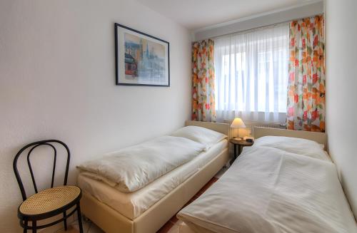 a room with two beds and a chair and a window at Ferienwohnung Tannenblick 3-2 in Oberhof