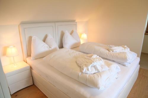 a bedroom with two beds with white sheets and pillows at Hof Niglberg Südsteiermark in Sankt Johann im Saggautal