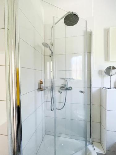 a shower with a glass door in a bathroom at Ferienwohnung am Olantis in Oldenburg