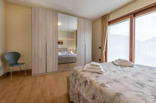 a bedroom with a bed and a chair and a mirror at Passioncasa in Torri del Benaco