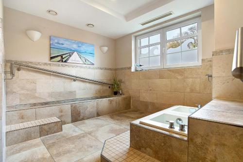 a bathroom with a tub and a sink and a window at Wellness-Residenz Wohnung 19 in Zingst