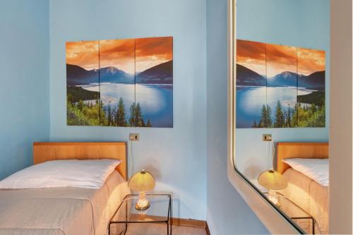 a bedroom with two beds and a painting on the wall at Brezza del lago in Desenzano del Garda
