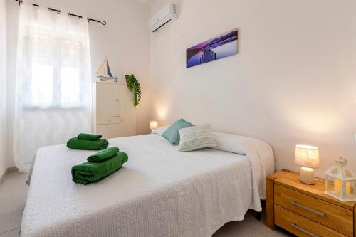 a bedroom with two beds with green towels on them at Villetta I Pitosfori in Palmadula