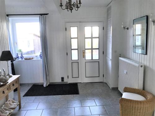 a white room with a door and a table and chairs at Haus Sonnenschein in Janneby