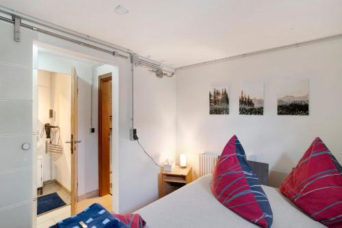 a bedroom with a bed with red and blue pillows at Loft Sven in Baden-Baden
