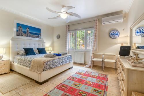 a bedroom with a king sized bed and a desk at Villa Shalimar Moraira in Teulada