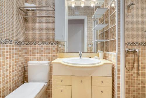 a bathroom with a sink and a toilet and a mirror at Villa Shalimar Moraira in Teulada