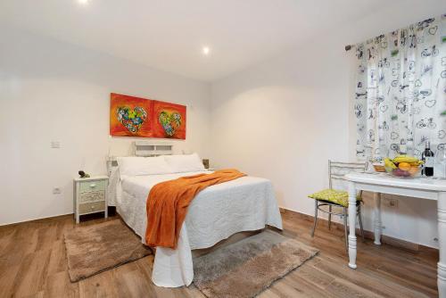 a bedroom with a bed with an orange blanket on it at El Lagar in Los Silos