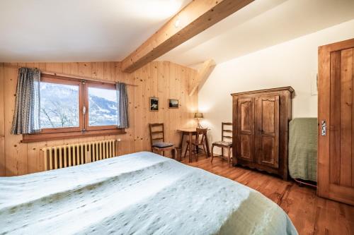 a bedroom with a bed and a window and a table at Chalet Franclair in Samoëns