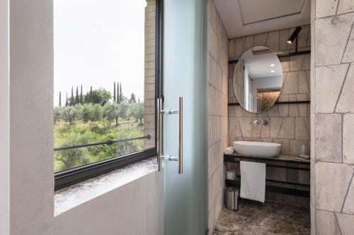 a bathroom with a sink and a window with a view at Suite Fattoressa in San Gimignano