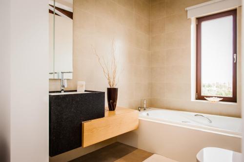 a bathroom with a white bath tub and a window at Can Vadell in Calonge