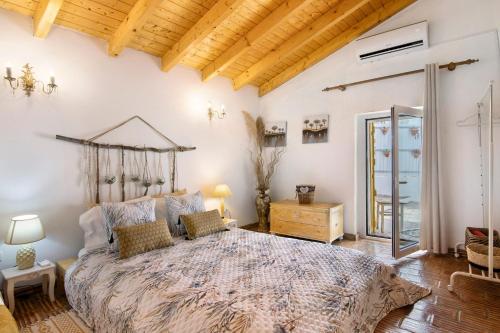 a bedroom with a large bed and a wooden ceiling at Quinta do Silêncio T4 in Tavira