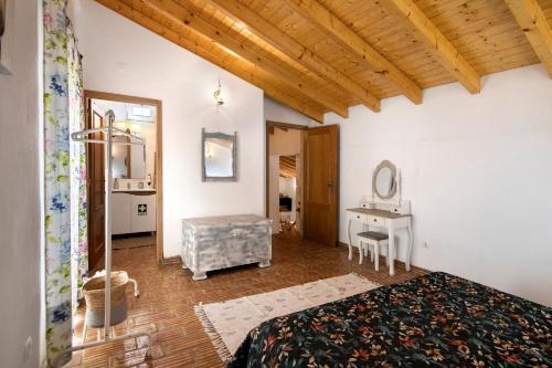 a bedroom with a bed and a desk with a mirror at Quinta do Silêncio T4 in Tavira