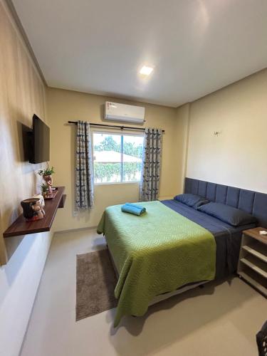 a bedroom with a bed and a window at Flat 2 Suítes, piscina e churrasqueira em Alter in Alter do Chao