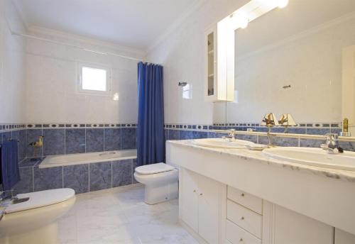 a bathroom with two sinks and a toilet and a tub at Casa Mcelroy in Tías