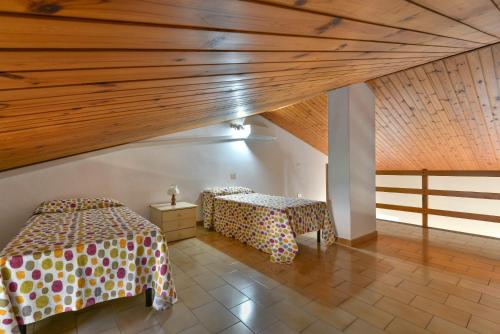 a room with two beds and a wooden ceiling at Il Quadrifoglio 3 in Procchio