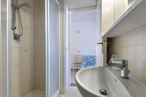 a bathroom with a tub and a sink and a shower at Il Quadrifoglio 3 in Procchio