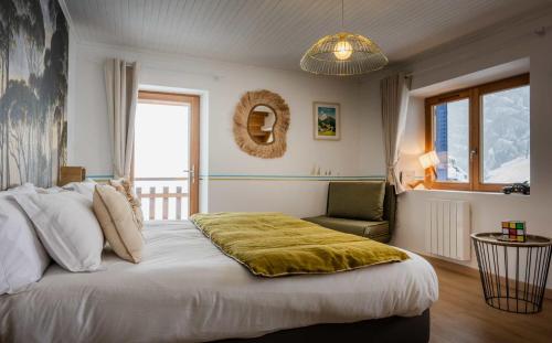 a bedroom with a large bed and a chair at La Colline aux Rêves - Chambres d'hôtes in Saint-Franc