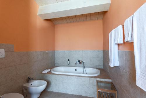 a bathroom with a tub and a toilet at Villa Pesca in Trequanda