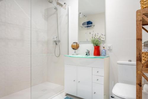 a white bathroom with a shower and a sink at Casa Sunny in Port de Soller