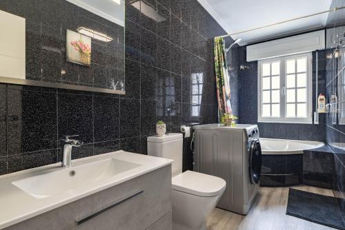 a bathroom with a sink and a toilet and a tub at Casita Do Muelle - Cambados in Cambados