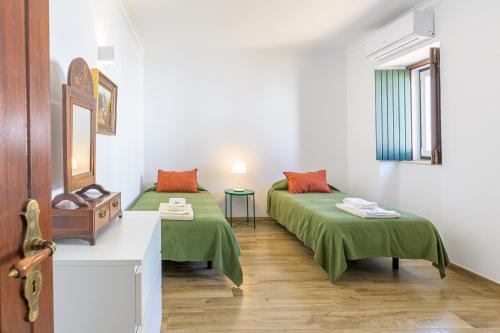 a room with two beds with green sheets at Herdade da Tamanqueira in Pomar