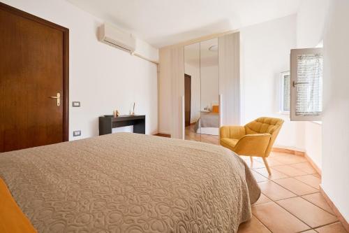 a bedroom with a bed and a chair at La Casa Di Simba A Piombino in Piombino