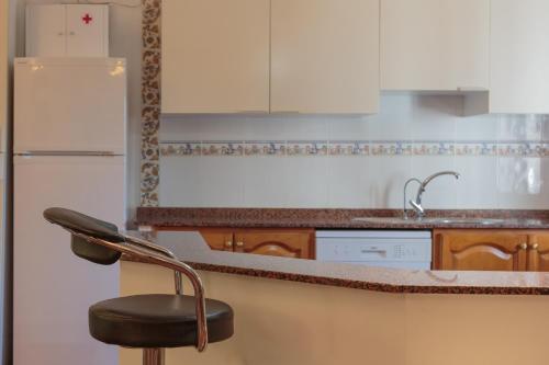 a kitchen with a counter and a chair in it at Villa Los Pinos in Marchena
