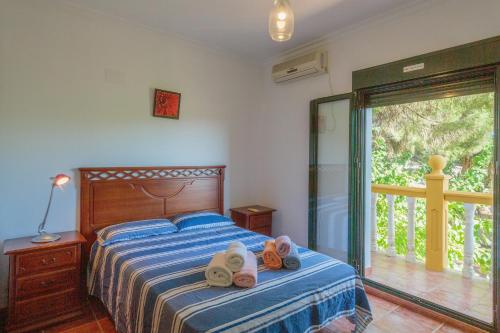 a bedroom with a bed with two towels on it at Villa Los Pinos in Marchena