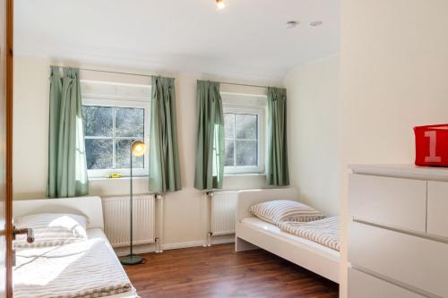 a bedroom with two beds and two windows at Friesenwald in Zetel