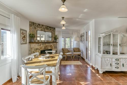 a dining room with a table and chairs and a fireplace at Ca la Yaya in Llança